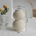 Beige ceramic vase with measurements on a white surface