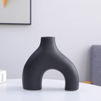 Black vase on a white surface with a neutral background