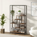 Bookshelf with decorative items in a room with a plant and a white couch.
