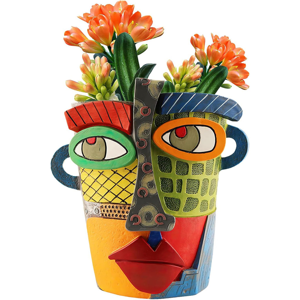 Colorful ceramic vase with face design holding succulents on a white background