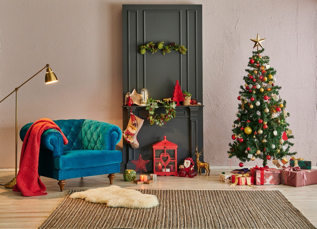 Living room decorated for Christmas with a tree, presents, and festive decor.