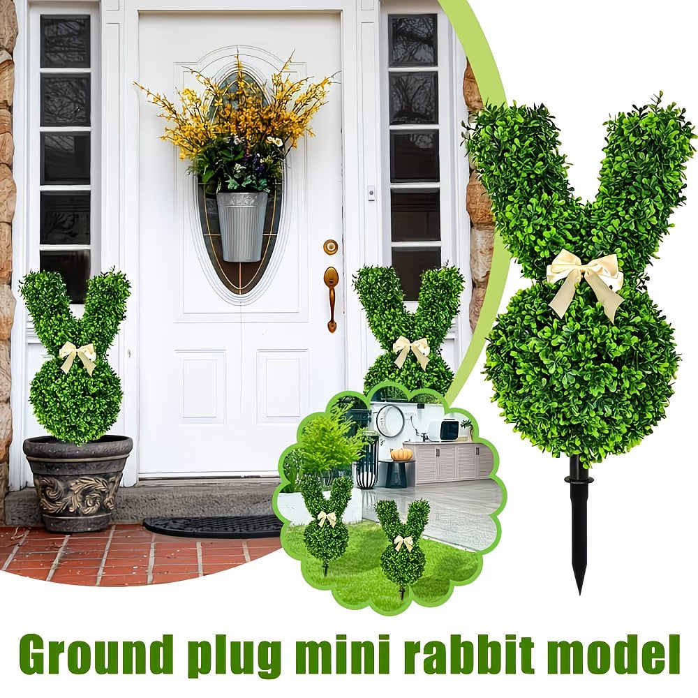 Decorative greenery shaped like a rabbit with a bow, placed in front of a white door.