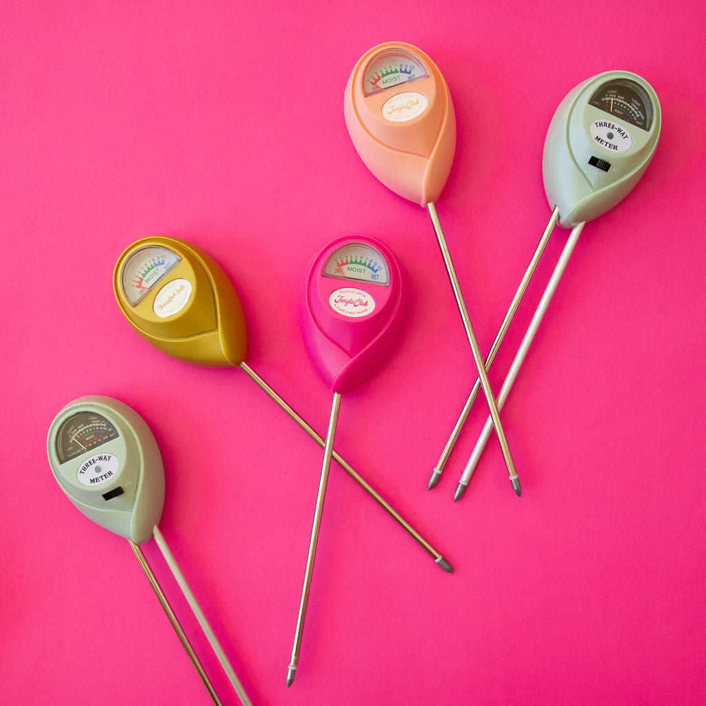 Set of colorful soil moisture meters on a pink background