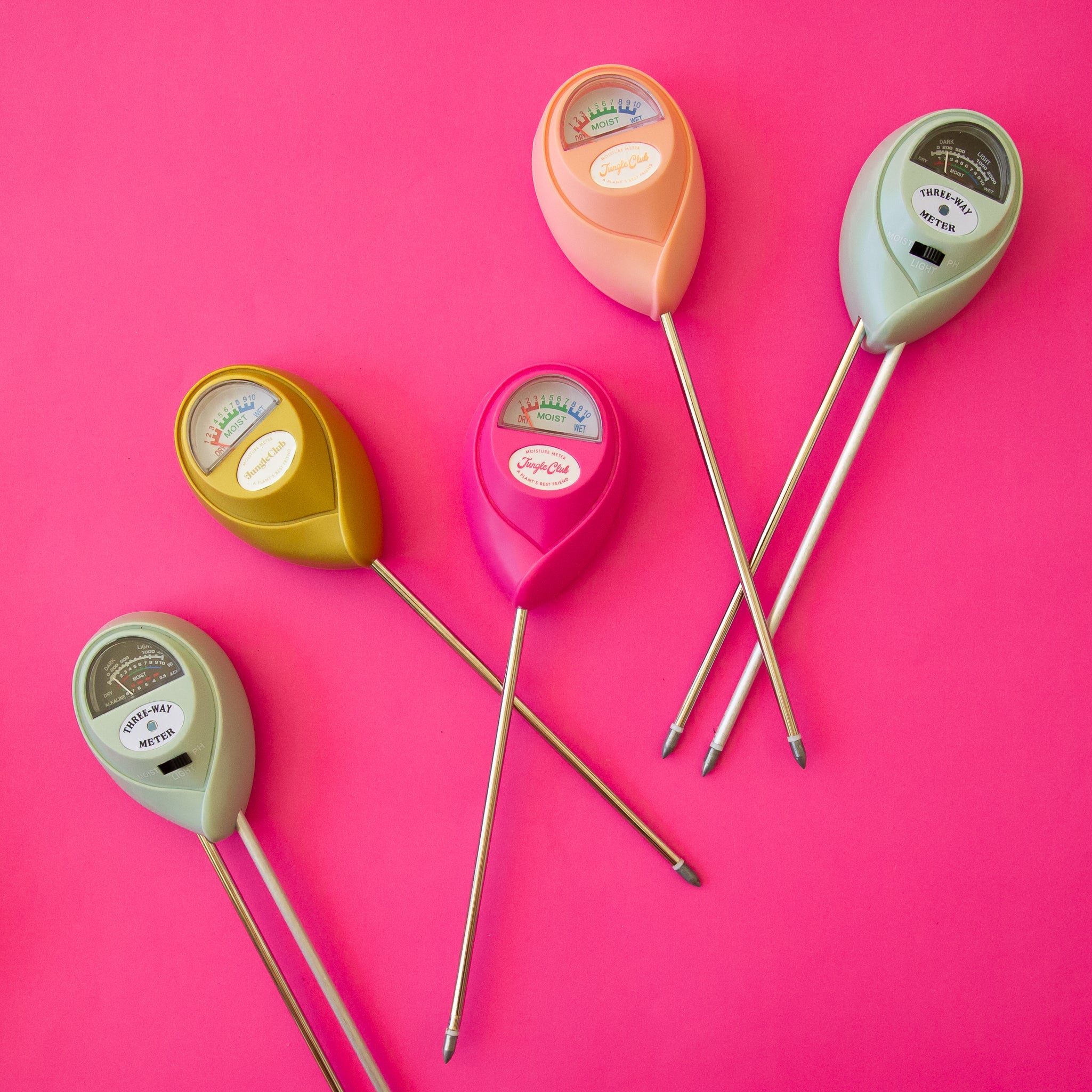 Set of colorful soil moisture meters on a pink background
