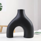 Black vase with unique design on a white surface