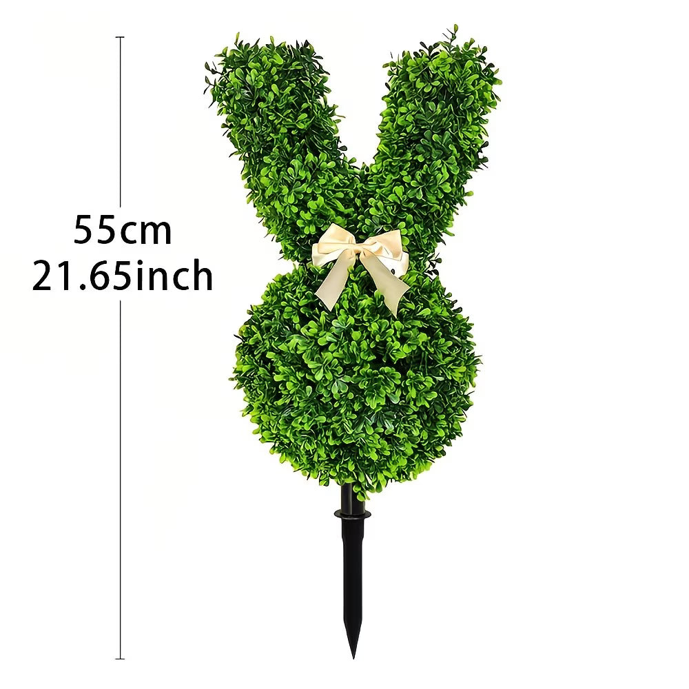 Decorative bunny topiary made of green foliage with a bow on a white background