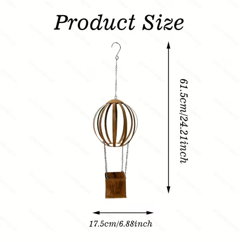 A hanging metal hot air balloon ornament with a brown wooden-look basket and chain, shown on a white background with dimension arrows and text indicating 61.5cm height and 17.