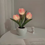 Decorative lamp with pink tulip-shaped lights on a white surface.