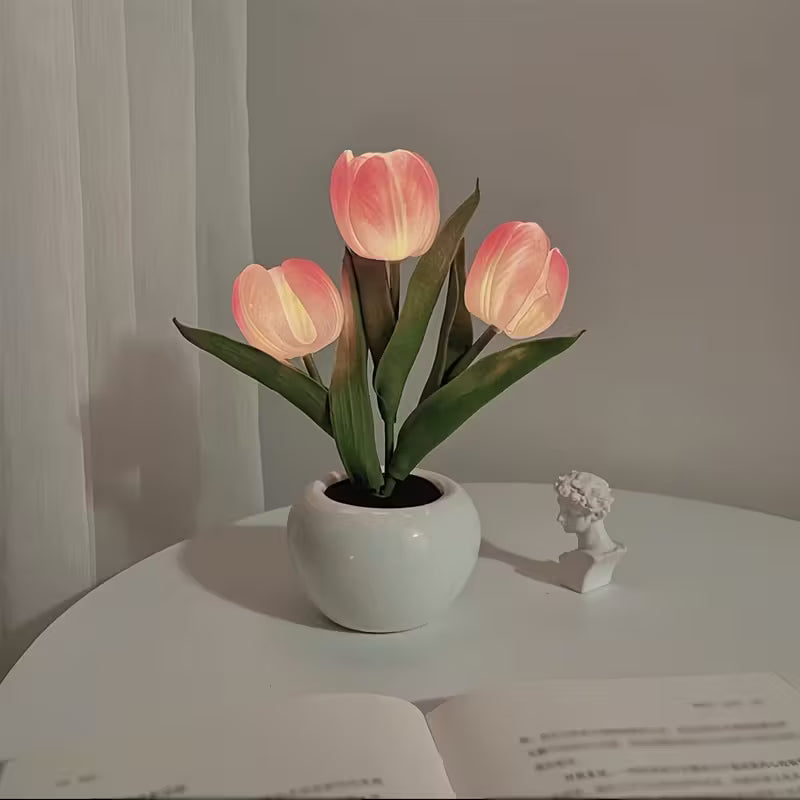 Decorative lamp with pink tulip-shaped lights on a white surface.