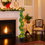 Decorative spiral plant with lights in a cozy living room with fireplace and Christmas decorations.